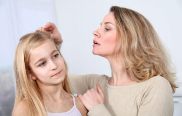 mother checking daughter for lice