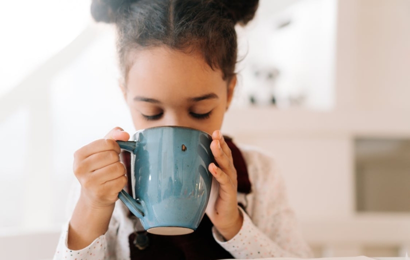 chica bebiendo de una taza azul