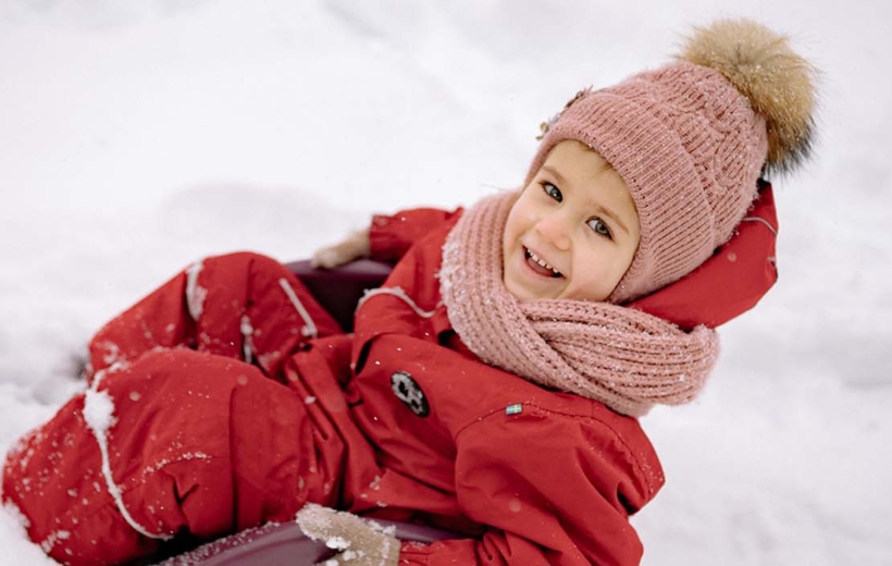 child on sled in snow